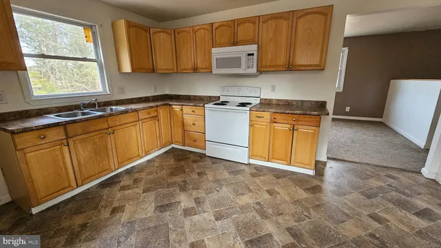 a kitchen with stainless steel appliances granite countertop a stove a sink and a white cabinets