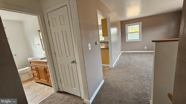 a view of a hallway with wooden floor and a living room