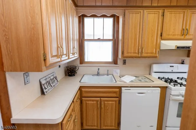 a view of a kitchen with window and cabinets