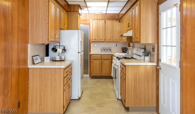 a kitchen with a window a sink dishwasher a refrigerator and cabinets
