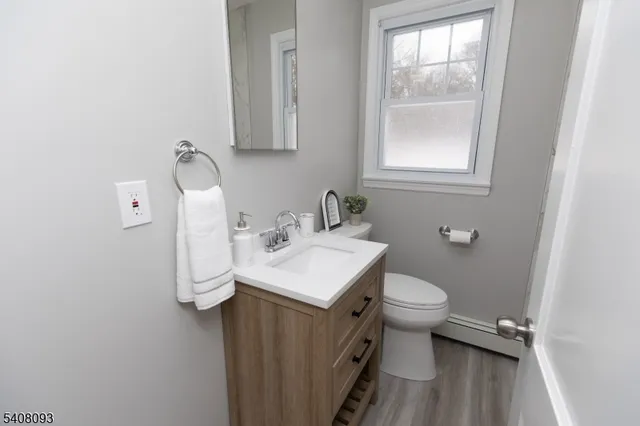 a bathroom with a sink toilet and a window