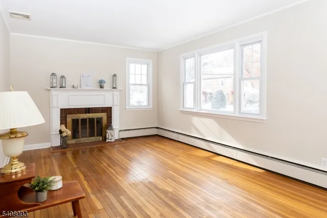 wooden floor fireplace and windows in an empty room