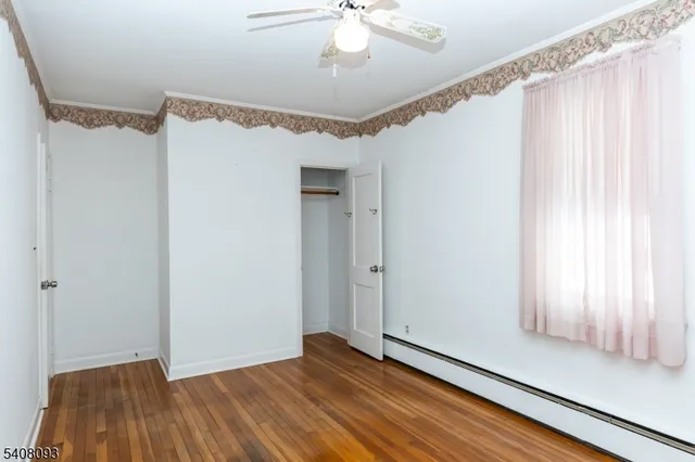 a view of a room with wooden floor staircase and a ceiling fan