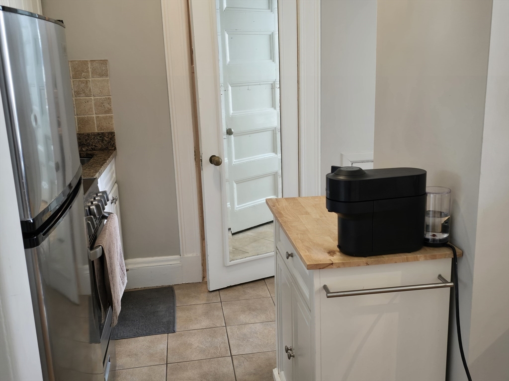 21 Beacon Street, Unit 10C Boston, MA 02108 - Photo 7 of 20 a living room with a couch and a refrigerator