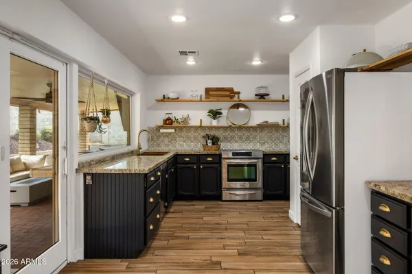 a kitchen with stainless steel appliances granite countertop a refrigerator and a stove top oven