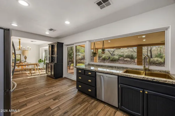 a open kitchen with stainless steel appliances granite countertop a refrigerator and wooden cabinets