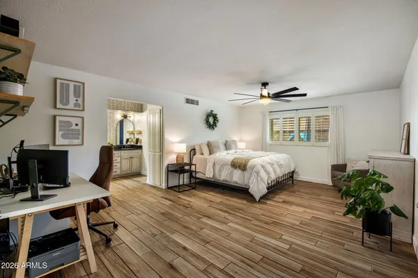 a bedroom with a bed wooden floor and a desk