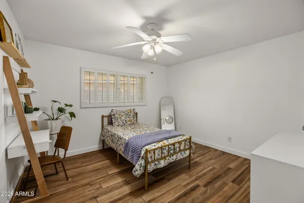 a bedroom with a bed and wooden floor