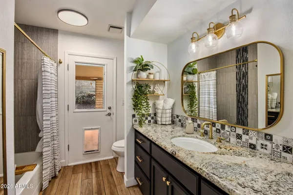 a bathroom with a granite countertop sink a large mirror and a shower