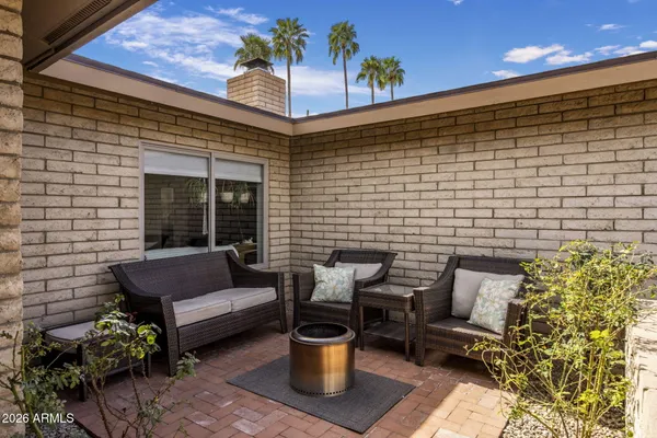 a view of a patio with couple of chairs and a potted plant