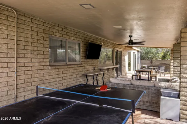 a living room with furniture a flat screen tv and a floor to ceiling window