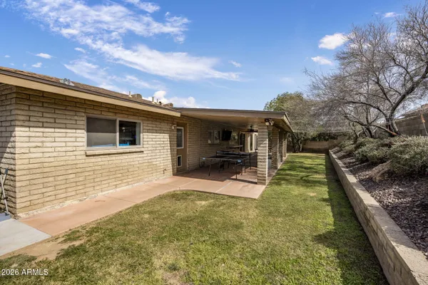 a view of a house with backyard and sitting area