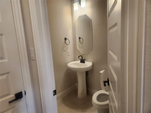 a bathroom with a sink toilet and mirror