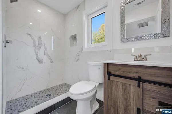 a bathroom with a toilet a sink and mirror