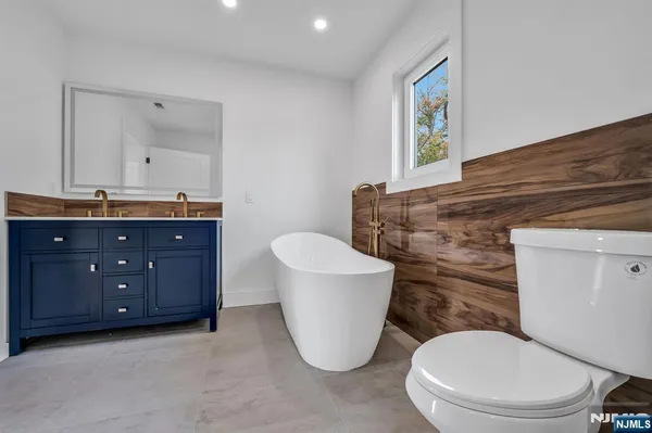 a bathroom with a granite countertop toilet sink and mirror