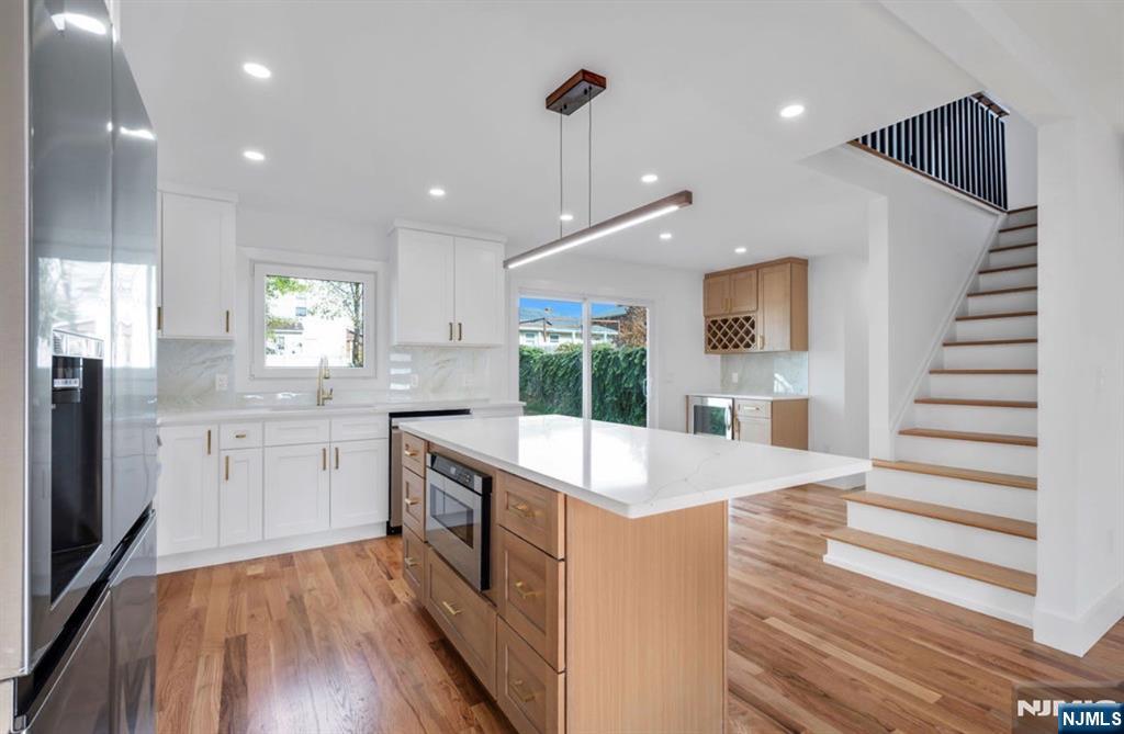 378 Marvin Avenue Hackensack, NJ 07601 - Photo 10 of 46 a large kitchen with kitchen island a stove a sink dishwasher and wooden floor