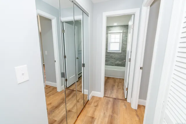 a view of a hallway with wooden floor and entryway