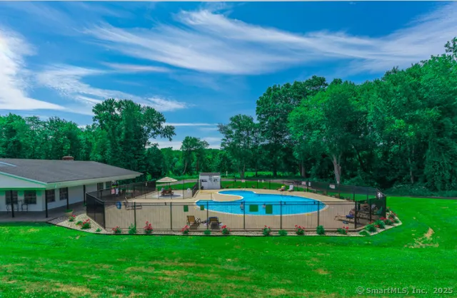 a view of a house with a swimming pool and a yard