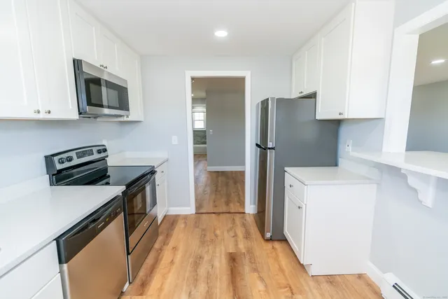 a kitchen with stainless steel appliances a refrigerator a stove top oven a sink and dishwasher