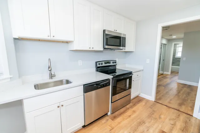 a kitchen with white cabinets and stainless steel appliances
