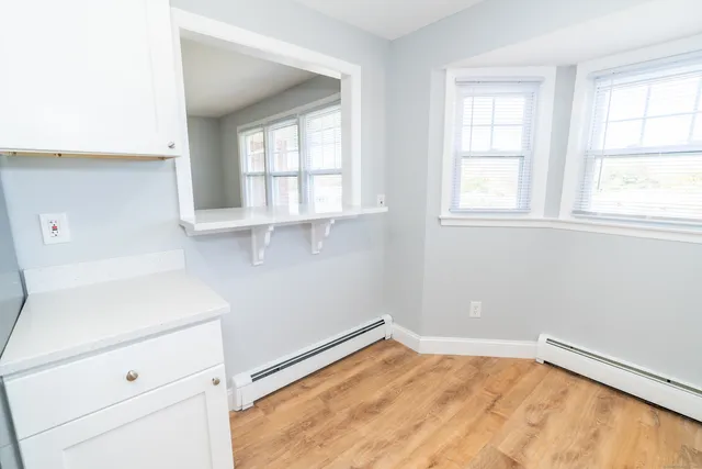 a view of a kitchen with wooden floor and cabinets