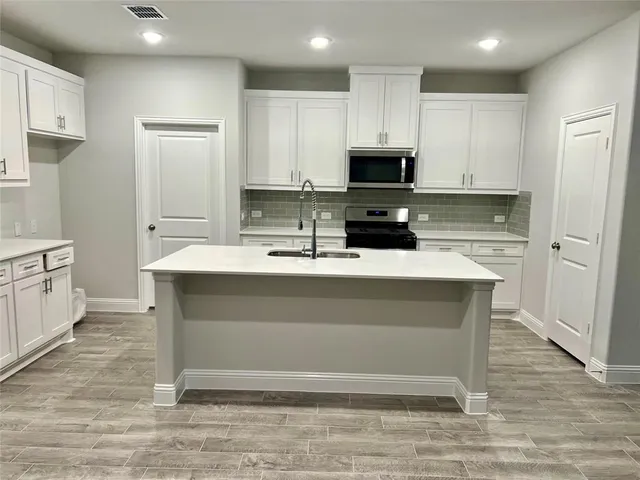 a kitchen with a sink cabinets and appliances