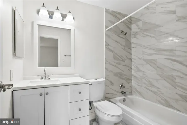 a bathroom with a sink vanity granite toilet tub and shower