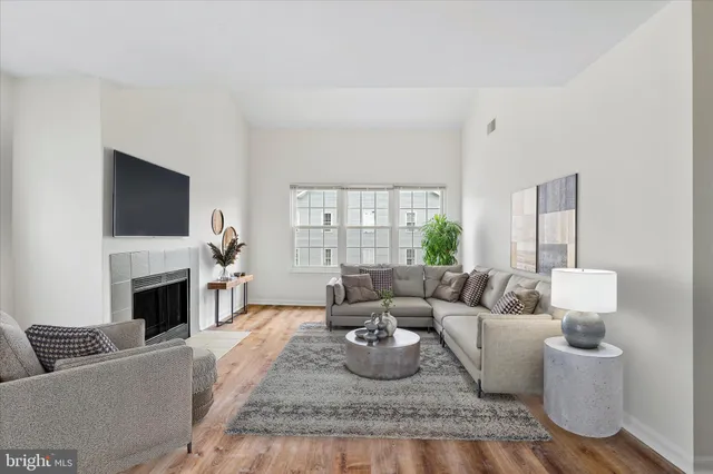 a living room with furniture a flat screen tv and a fireplace
