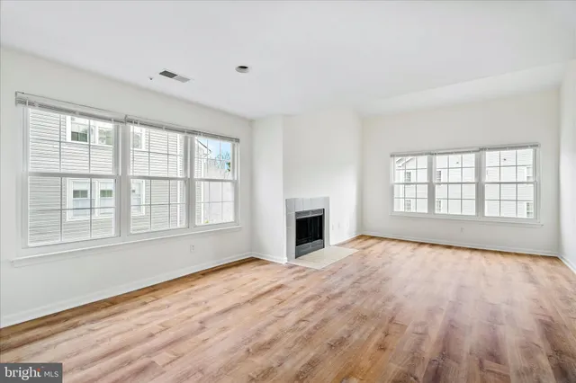 a view of an empty room with a window and fireplace