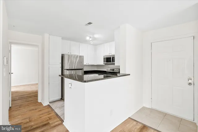 a kitchen with stainless steel appliances granite countertop a refrigerator and a stove