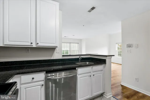 a kitchen with granite countertop white cabinets and a stove