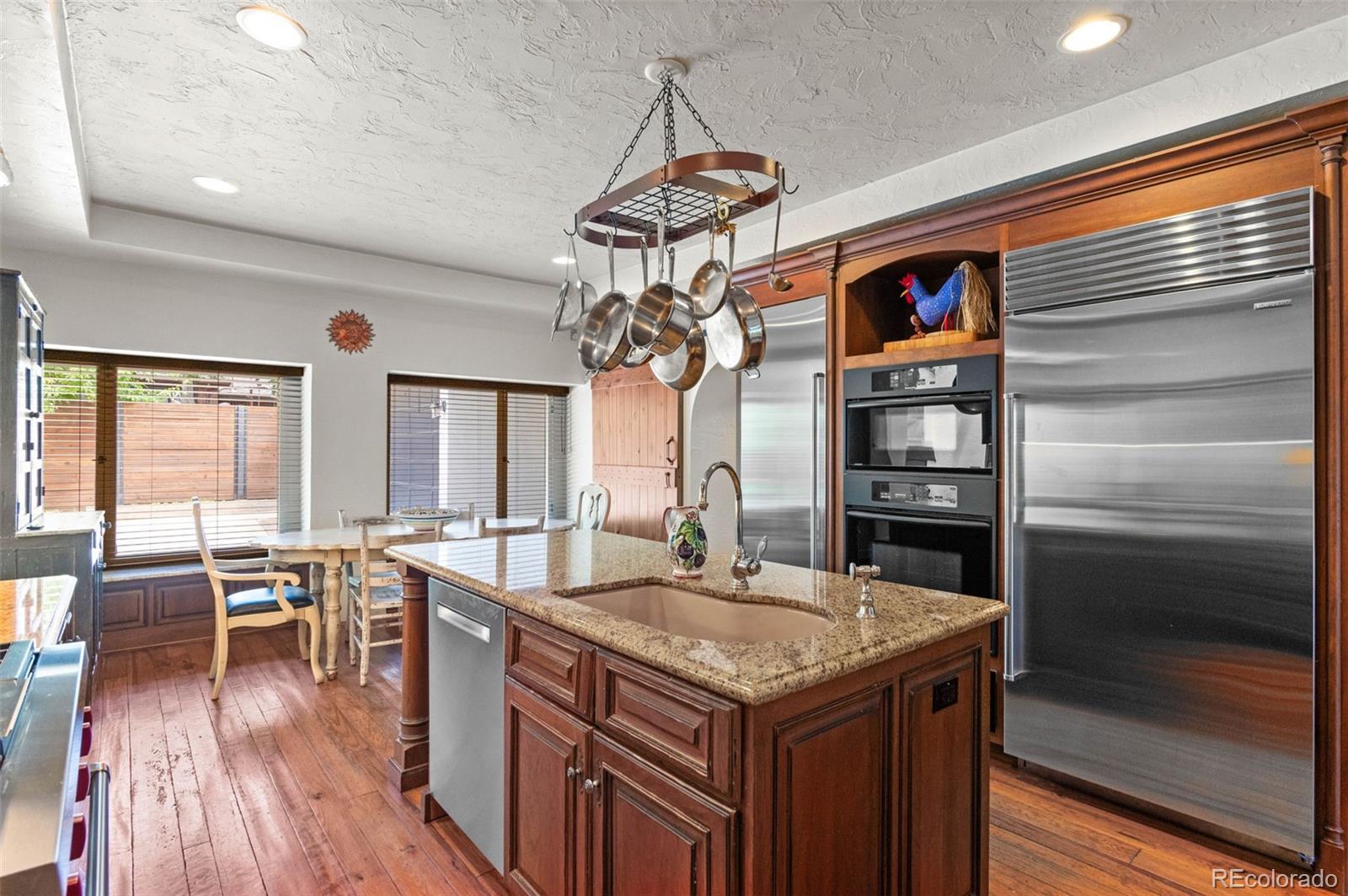50 Albion Street Denver, CO 80220 - Photo 3 of 49 a kitchen with center island wooden floor and stainless steel appliances