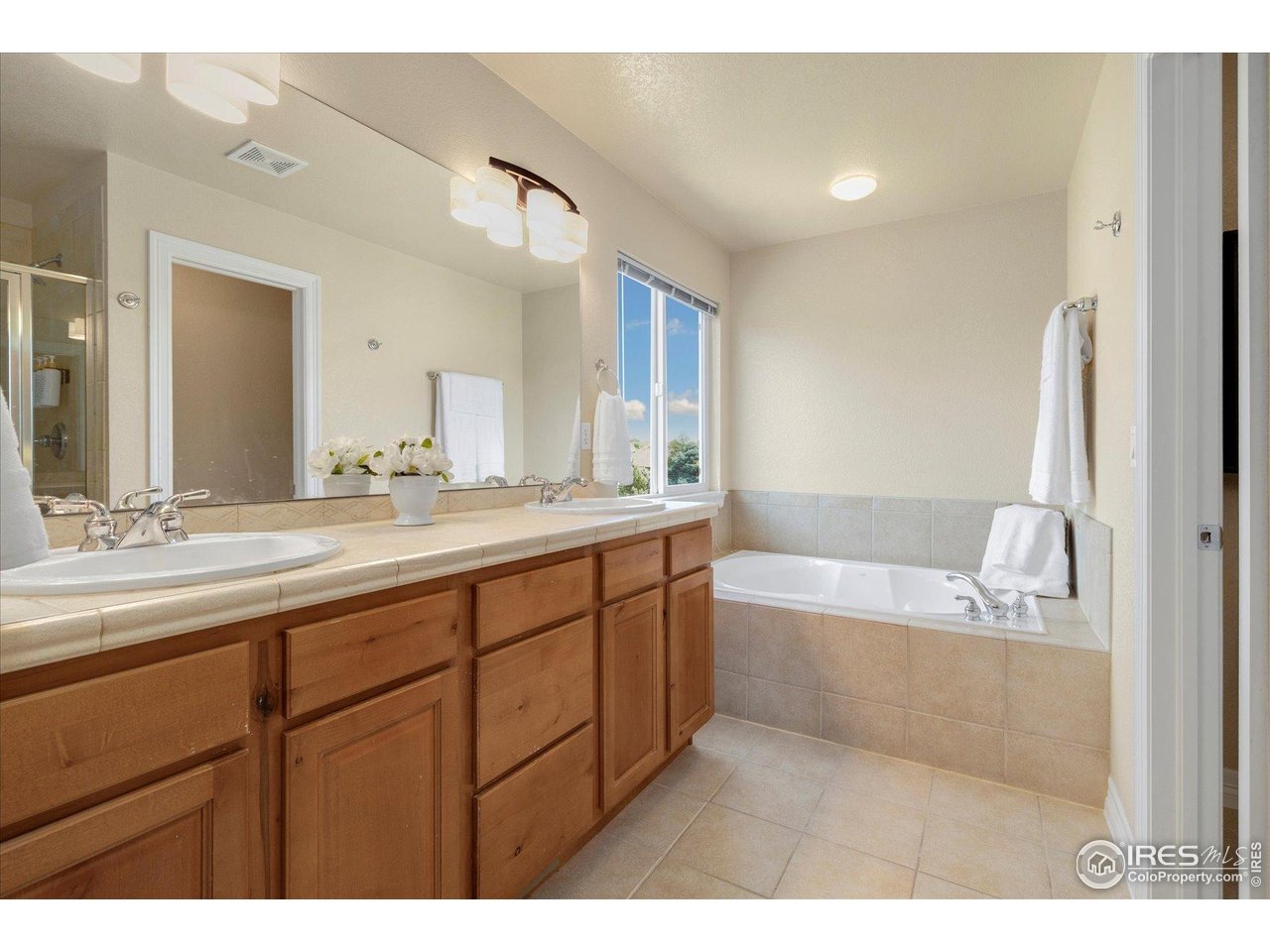 16836 Roberts Street Mead, CO 80542 - Photo 22 of 27 a spacious bathroom with a tub sink and mirror