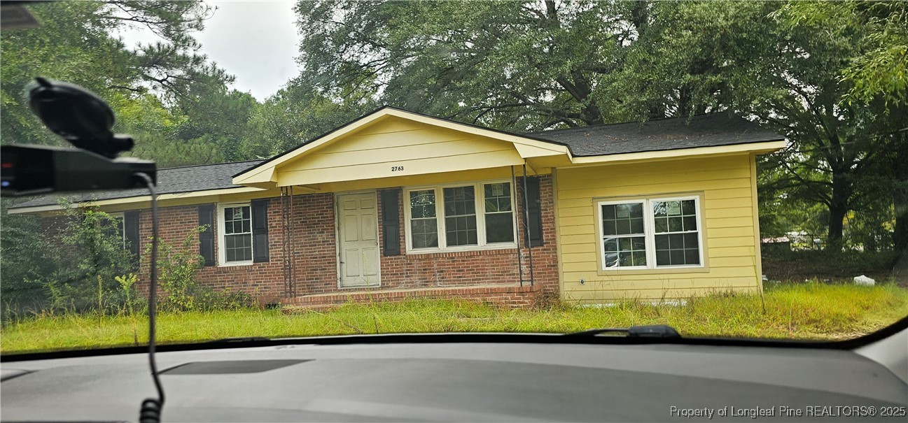 a view of a house with a small yard plants and large tree