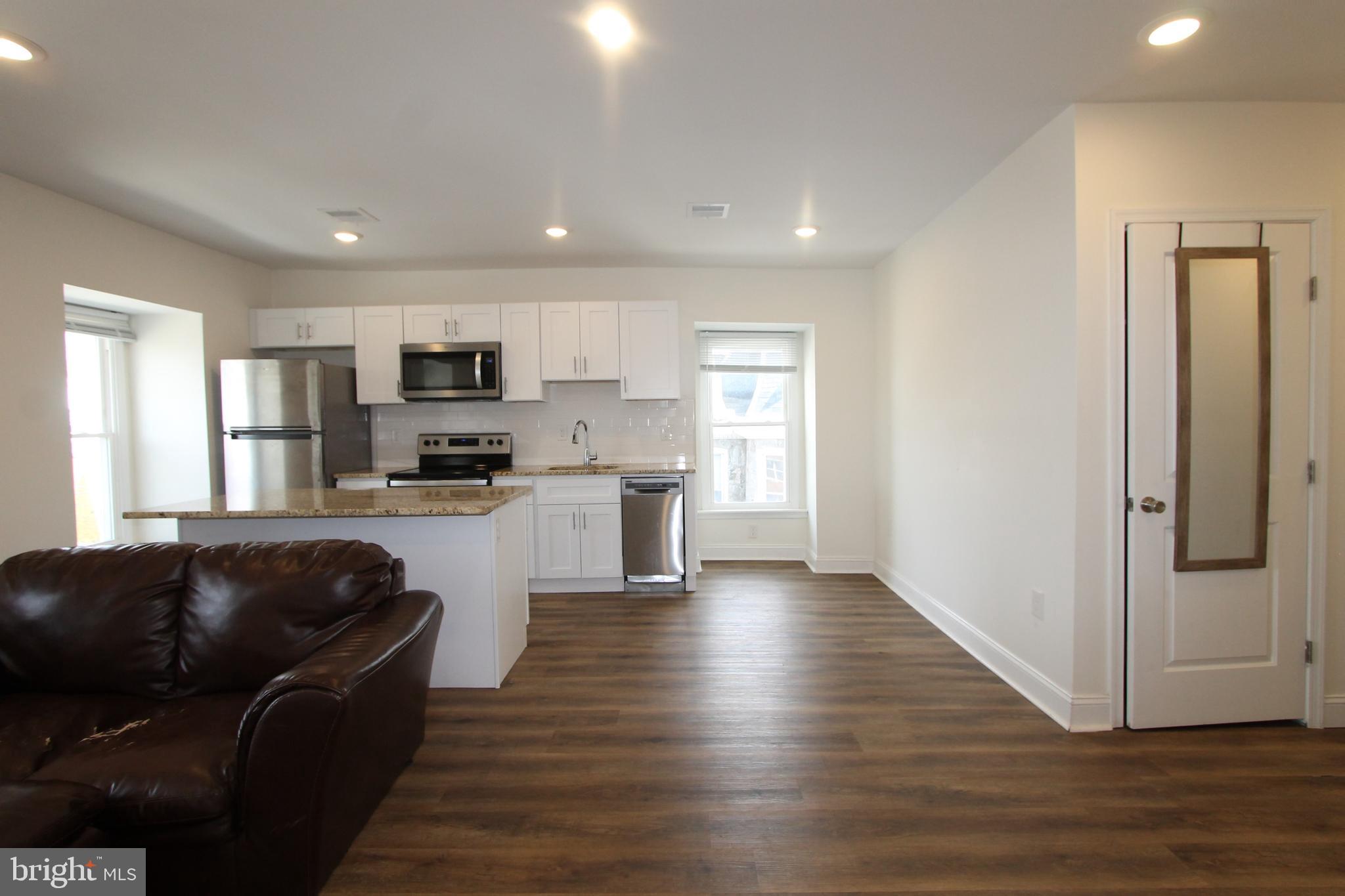 204 High Street Philadelphia, PA 19144 - Photo 4 of 19 a kitchen with granite countertop a refrigerator and wooden floor