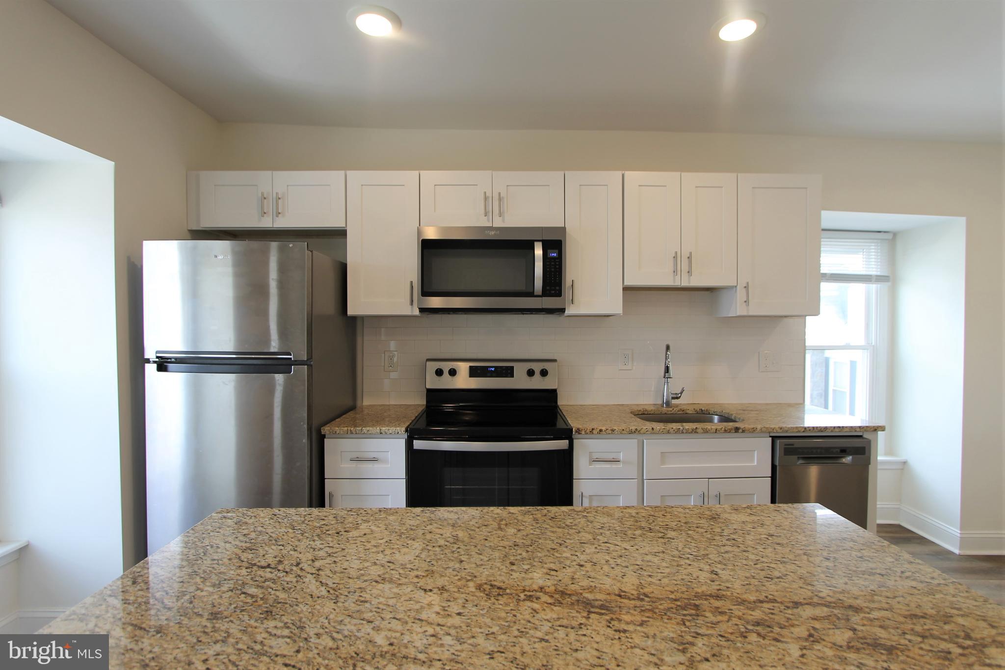 204 High Street Philadelphia, PA 19144 - Photo 6 of 19 a kitchen with a refrigerator and a stove top oven