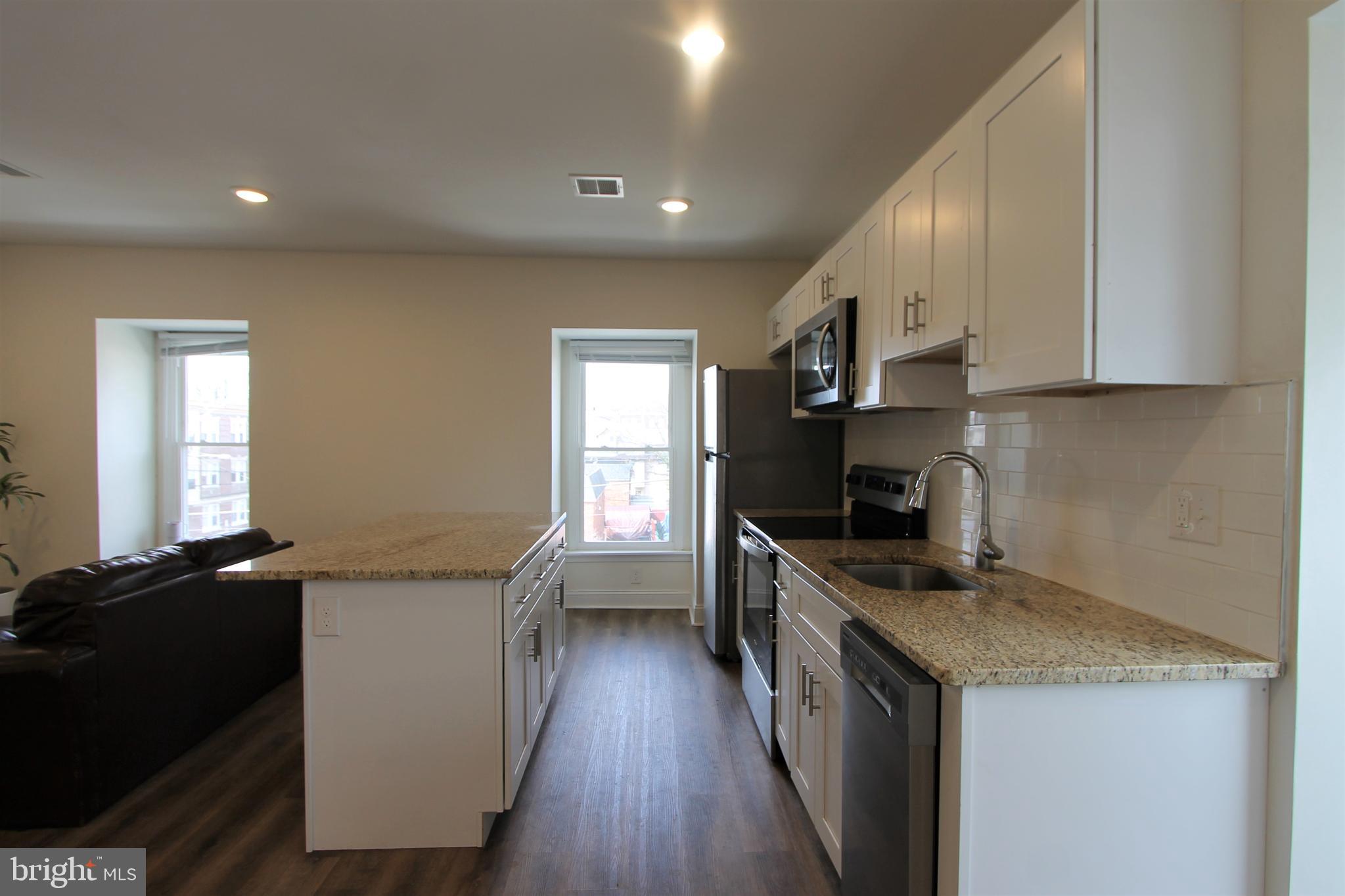 204 High Street Philadelphia, PA 19144 - Photo 8 of 19 a kitchen with granite countertop a sink a counter top space stainless steel appliances and a window