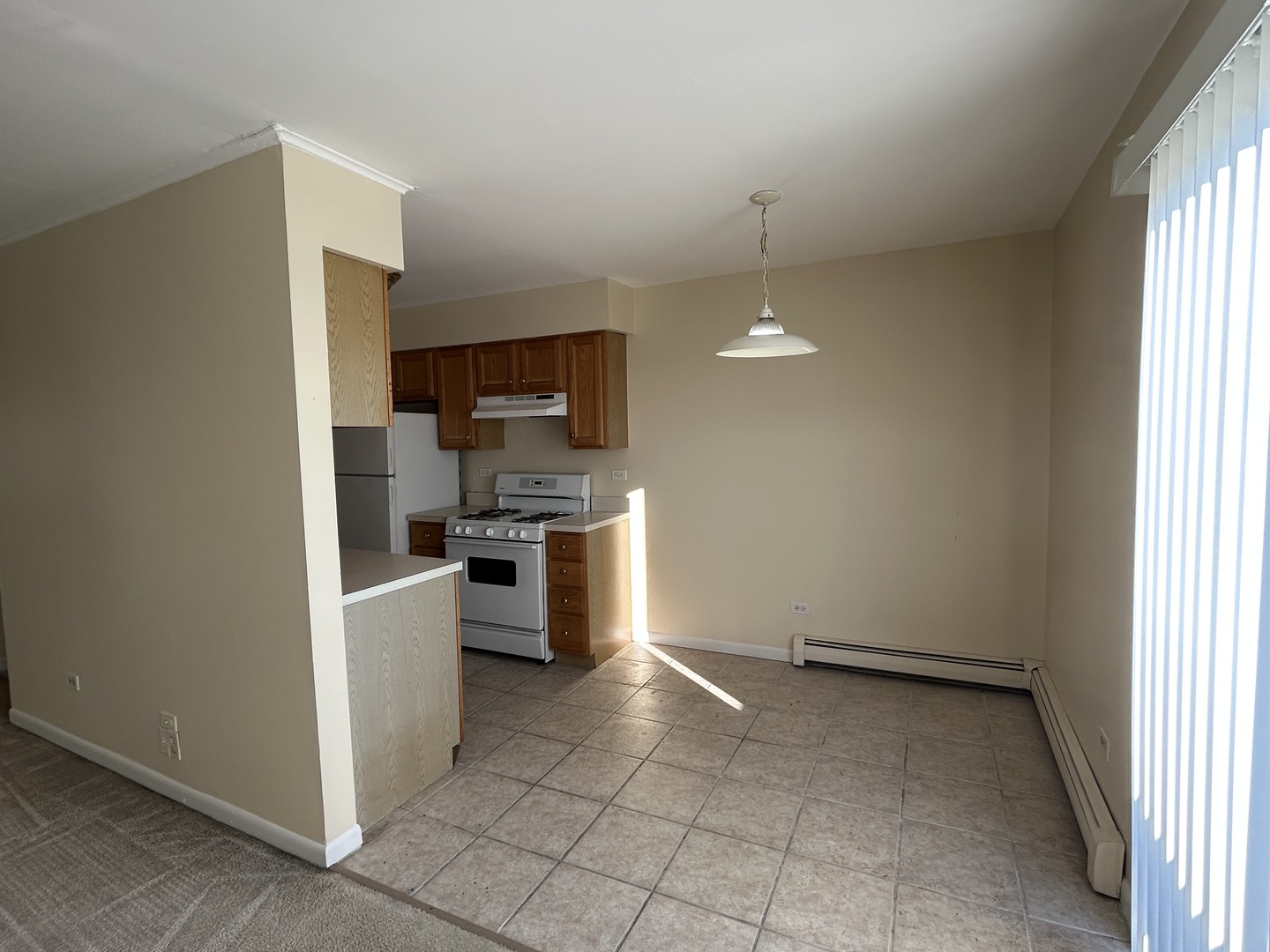 1120 Copperfield Lane, Unit E Schaumburg, IL 60193 - Photo 3 of 9 a kitchen with a refrigerator and a stove top oven