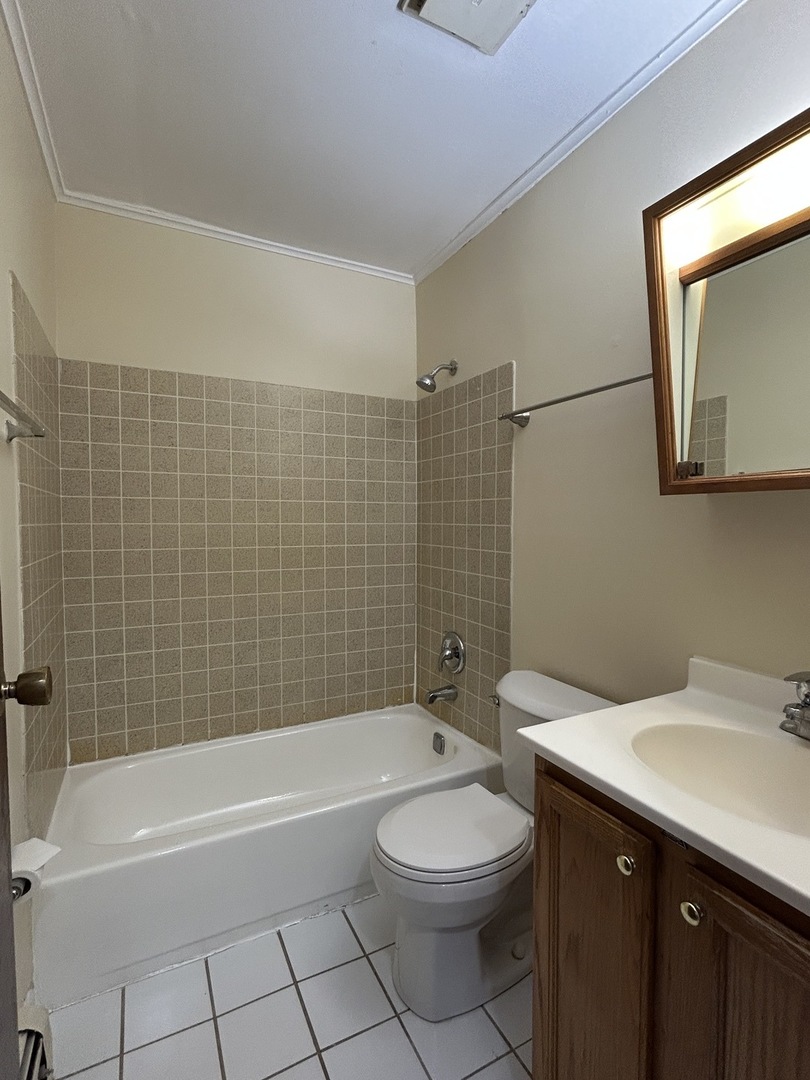 1120 Copperfield Lane, Unit E Schaumburg, IL 60193 - Photo 7 of 9 a bathroom with a bathtub a sink a toilet and a mirror