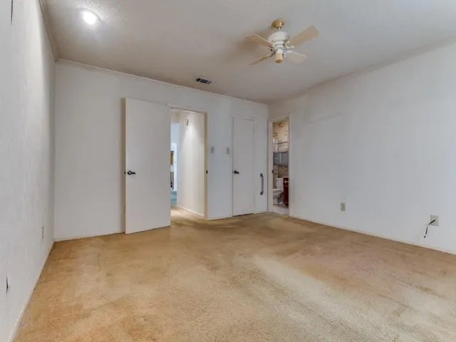 a view of an empty room with a ceiling fan