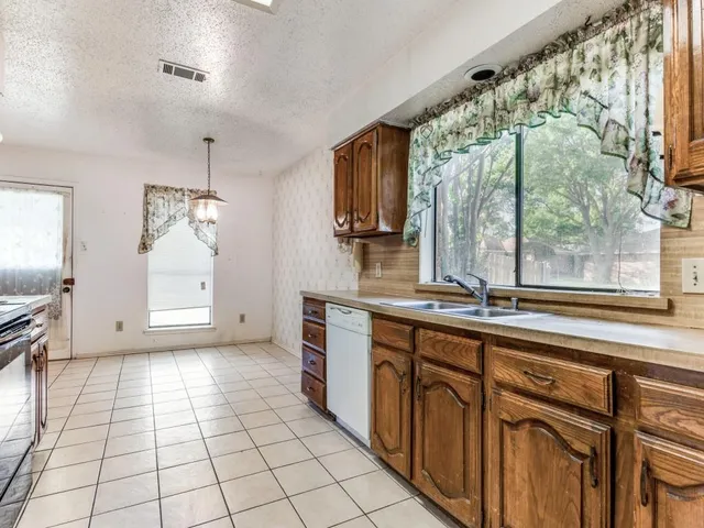 a kitchen with a sink a counter top space and stainless steel appliances
