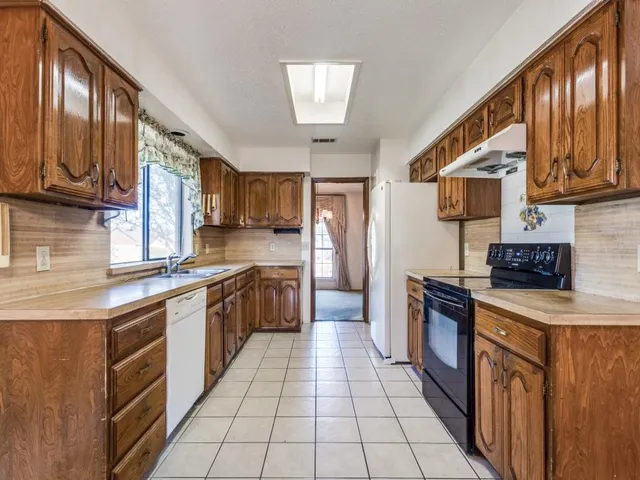a kitchen with stainless steel appliances granite countertop a stove a sink dishwasher and a refrigerator