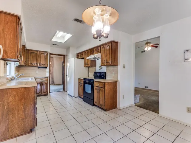 a kitchen with stainless steel appliances granite countertop a refrigerator and a stove top oven