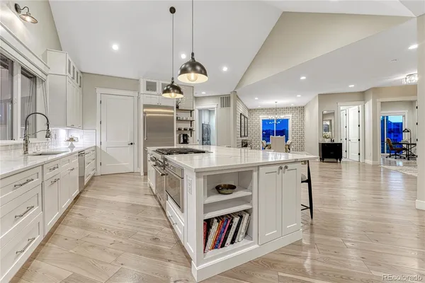 a kitchen with stainless steel appliances a table chairs refrigerator and sink