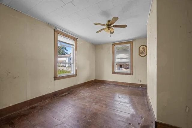 a view of a big room with wooden floor and windows