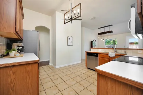 a kitchen with stainless steel appliances granite countertop a sink a stove and refrigerator