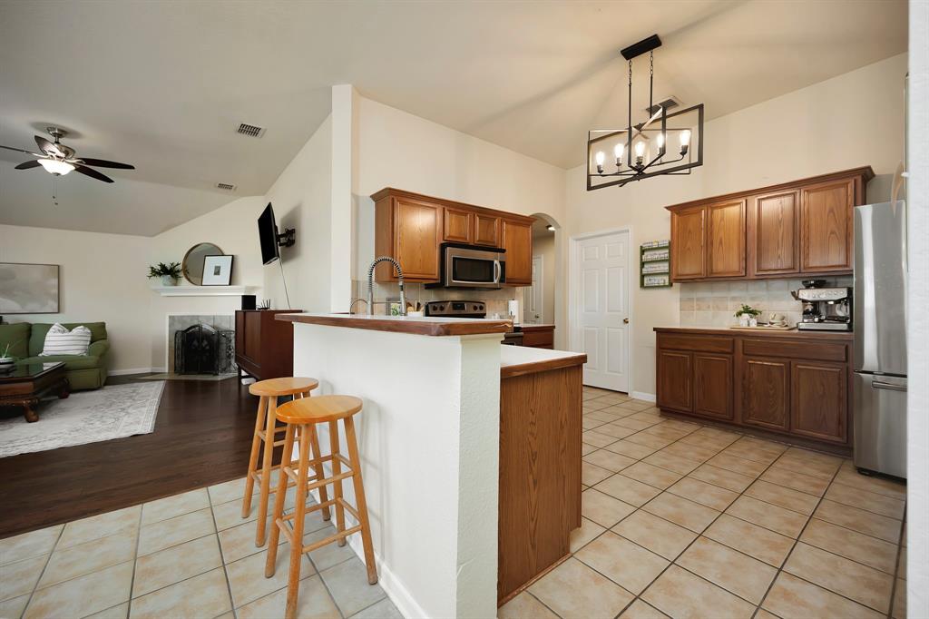 1333 Missionary Ridge Trail Fort Worth, TX 76131 - Photo 12 of 31 a kitchen with stainless steel appliances a microwave a stove a sink dishwasher a refrigerator and a microwave