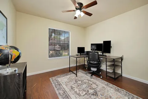 a view of a workspace with furniture and a window