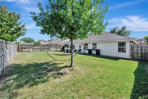 a view of a house with backyard and a tree