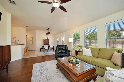 a living room with furniture a wooden floor and a large window
